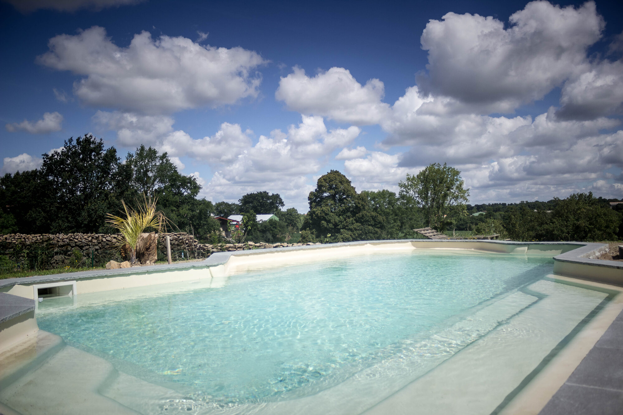 La piscine extérieure du Domaine des Fées avec vue sur le bocage vendéen, près du Puy du Fou